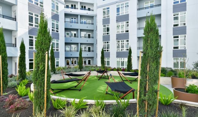 a courtyard with tables and chairs and plants in it