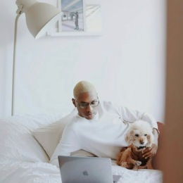 a person laying on a bed with a dog